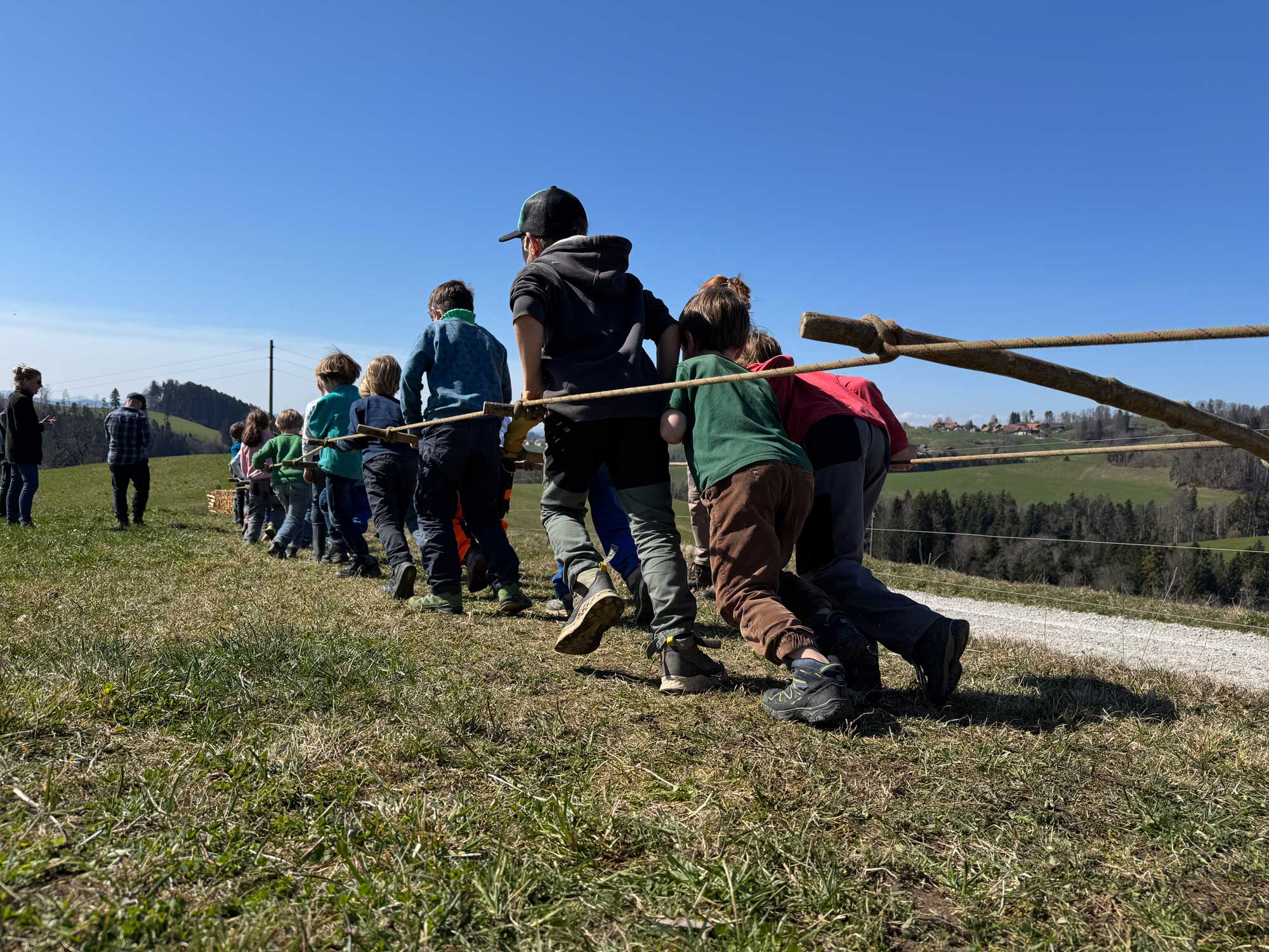 Kinder ziehen einen Pflug in der Bauernepoche der Steinerschule Bern Ittigen Langnau
